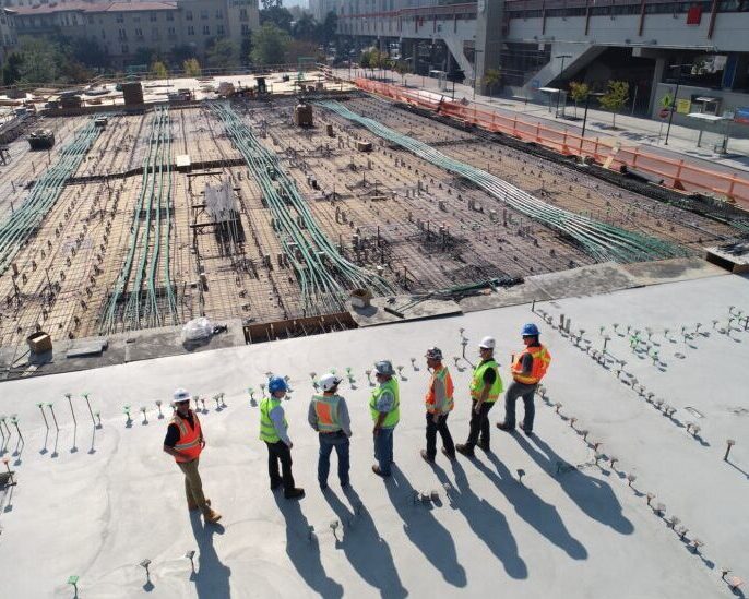 seven construction workers standing on white field